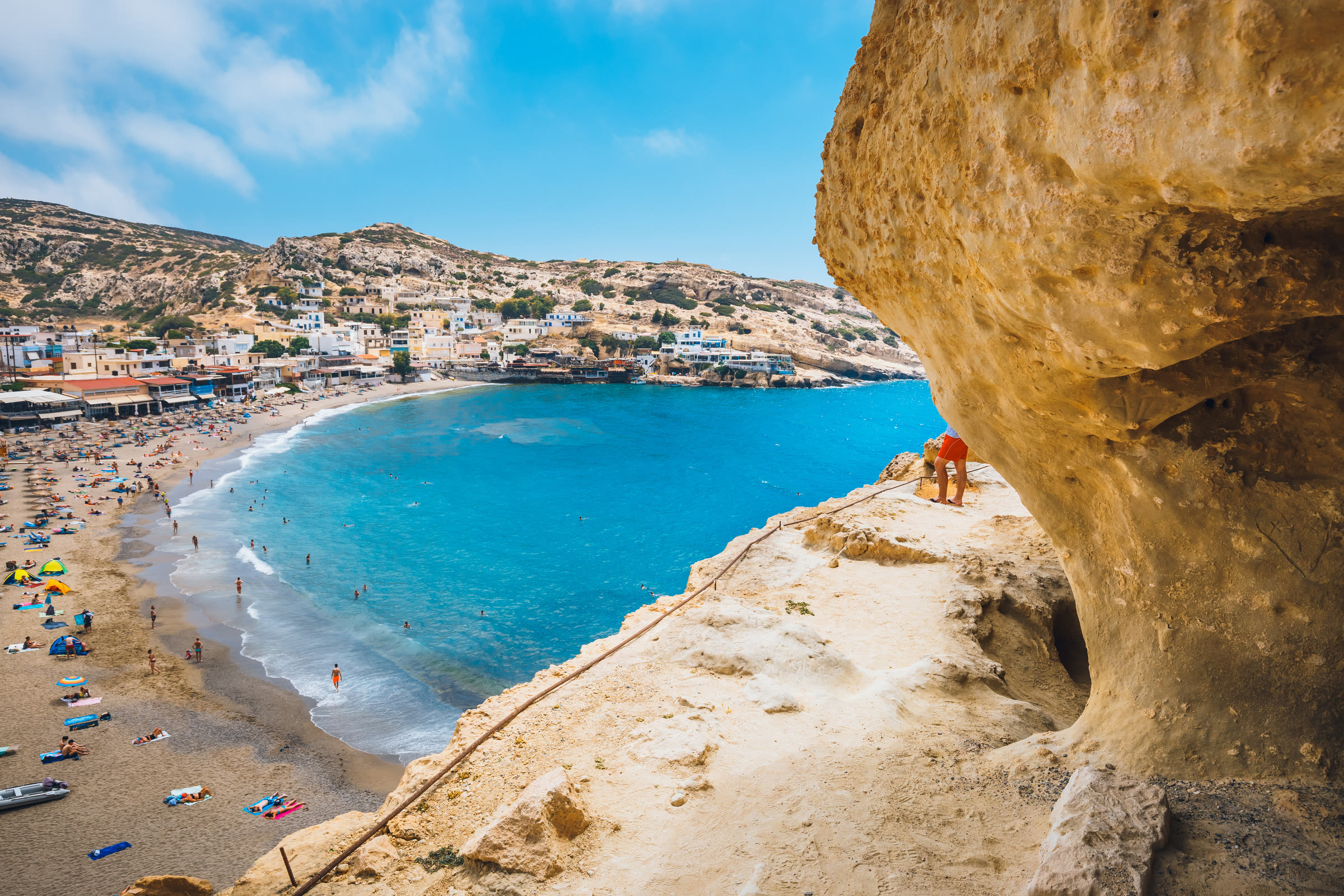 From the caves of Matala, the bay opens below in bright Mediterranean daylight.